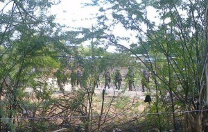 Kenya Defence Forces soldiers move behind a thicket in Garissa town in this photograph taken with a mobile phone
