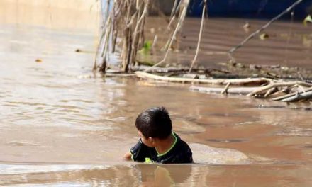 Niños hondureños víctimas de huracanes se bañan en aguas estancadas